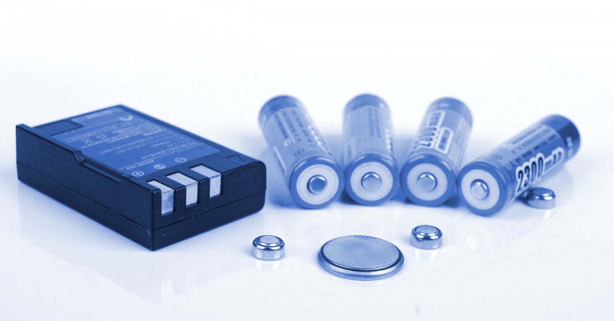 A collection of lithium-ion battery cells in various shapes and sizes sit in front of a white background.