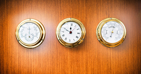 Three sailing boat dials set in a wood inlay. The leftmost dial shows a temperature reading of 70 degrees.